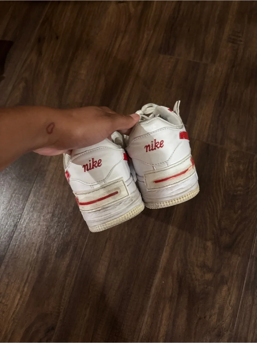 Nike Air Force 1 white sneakers with red Nike swoosh